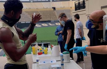 Drug Testing In Sports A group of people standing around a table