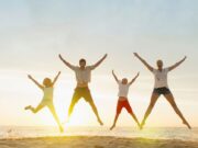 Enjoy your life in an entertainment-filled world Family doing star jumps on beach