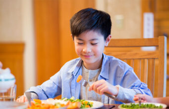 Why people give lots of importance to health? A boy eating aa food at dinning table