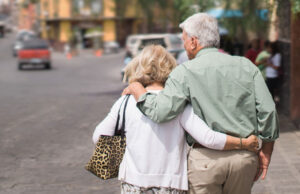 How a family and relationship take part in a person’s success? A old couple holding each other and walking on road